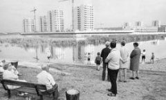 Onlookers by the lake watch the construction of Thamesmead, Greenwich, London